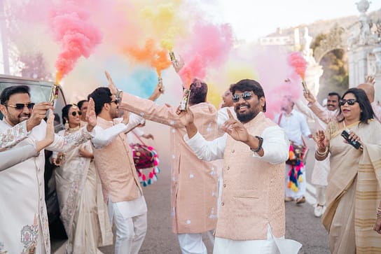 A group of Indian men dancing and waving coloured smoke flares.  They are all wearing traditional Indian wedding clothes.
Guests enjoying a lively Barat at an Indian wedding in Italy.  Arranged by Love Italy 
Weddings, the best Indian wedding planner in Italy.