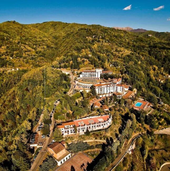 Aerial view of Il Ciocco wedding venue in Florence. The photo shows the large hotel complex from the air set high on a wooded hillside.