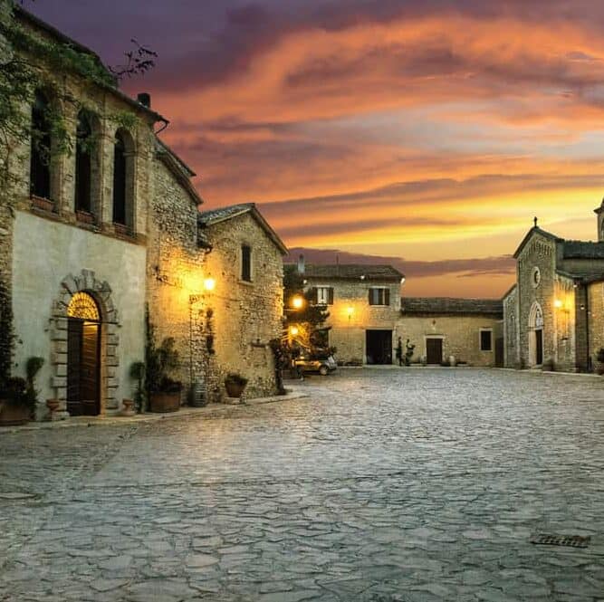 Large stone piazza surrounded by grand stone buildings.