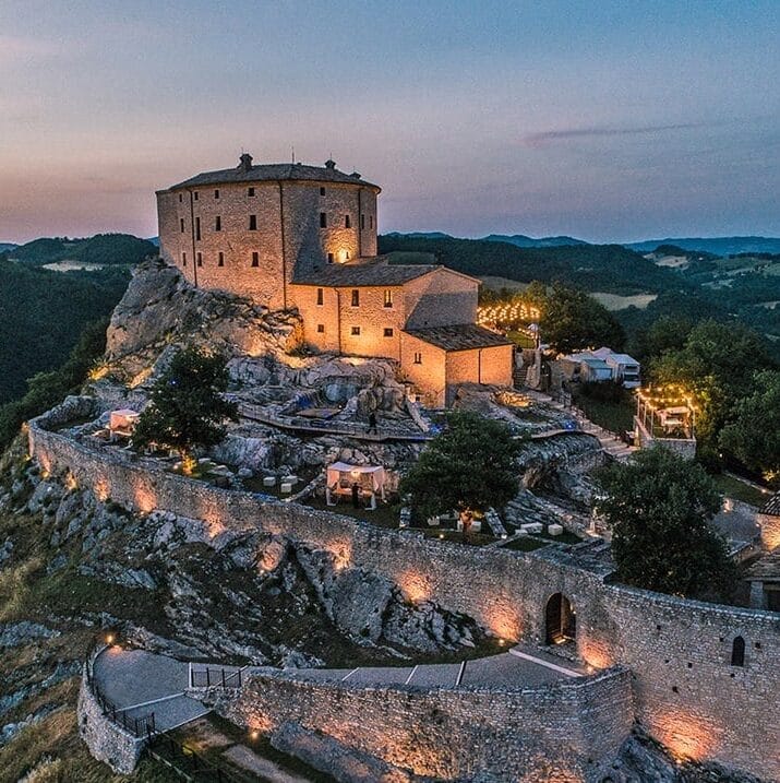 Castle on a rocky hill.  There are lights lining the path up to the castle.