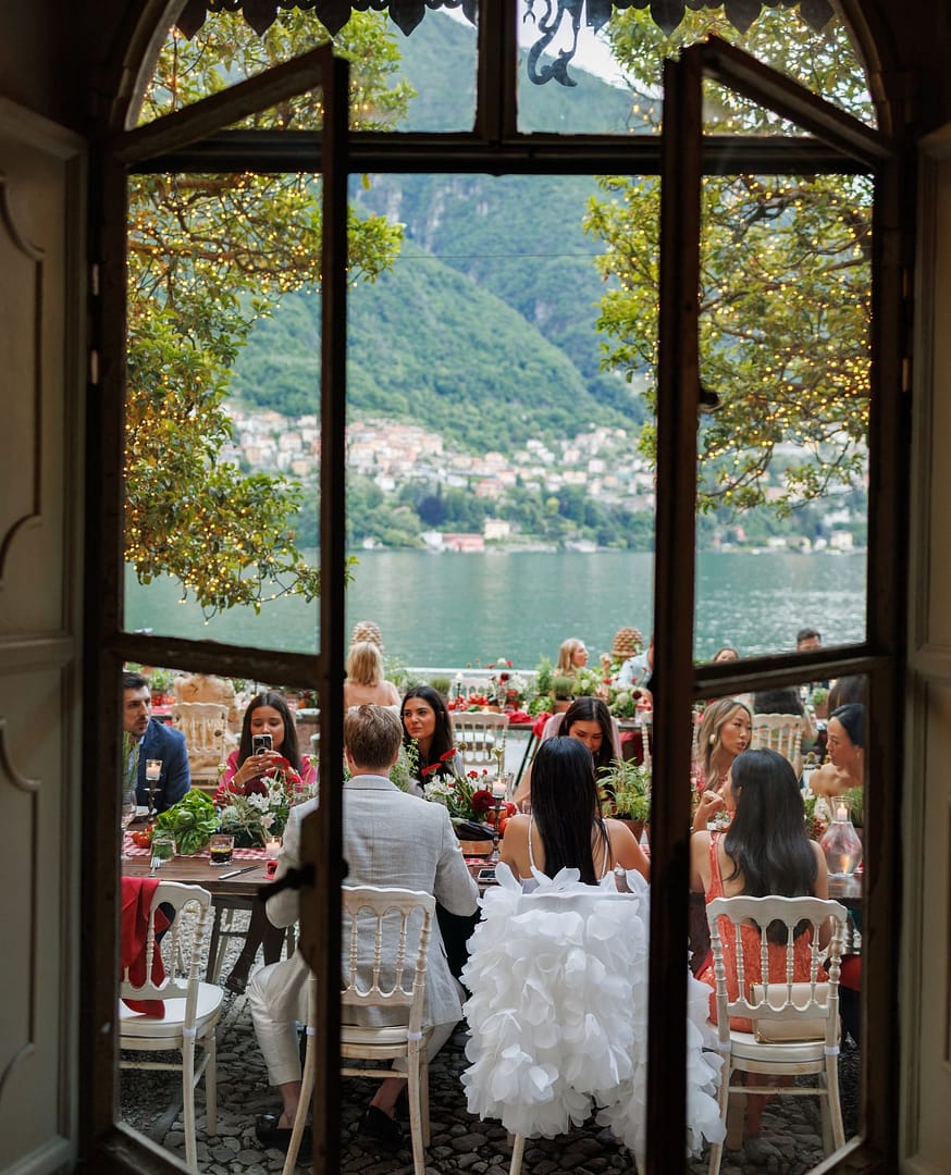 Italian villa with formal gardens. In front of the villa are four rectangular ponds with low hedges around them. There are lawns to the right of the ponds and olive groves to the left. The villa is at the back of the picture.